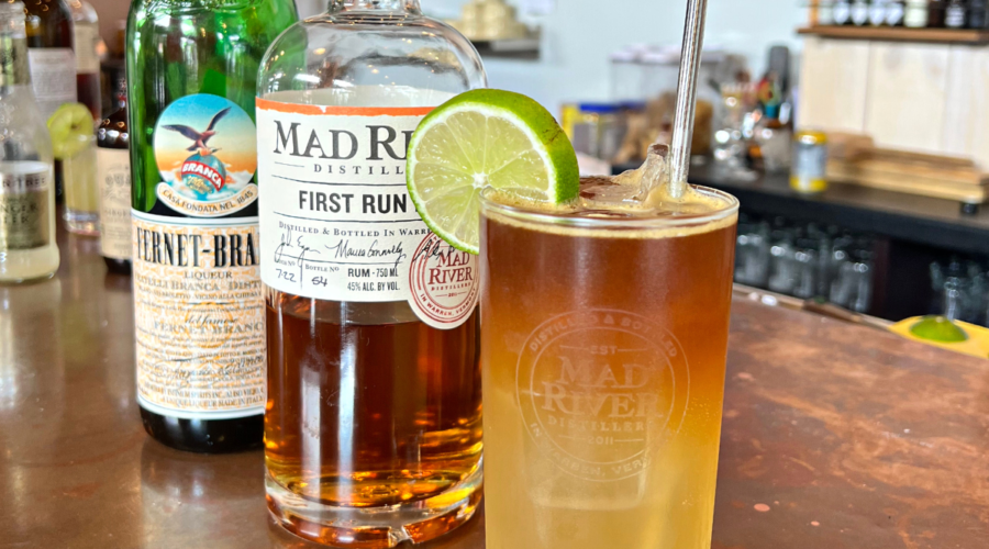 A Midday Reviver cocktail on the Mad River Distillers bar with a bottle of First Run Rum and Fernet in the background