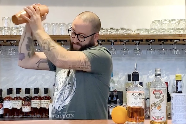 Bartender shakes a cocktail in a shaker.