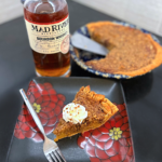 Bourbon Whiskey bottle, pecan pie, and slice of pie on a counter
