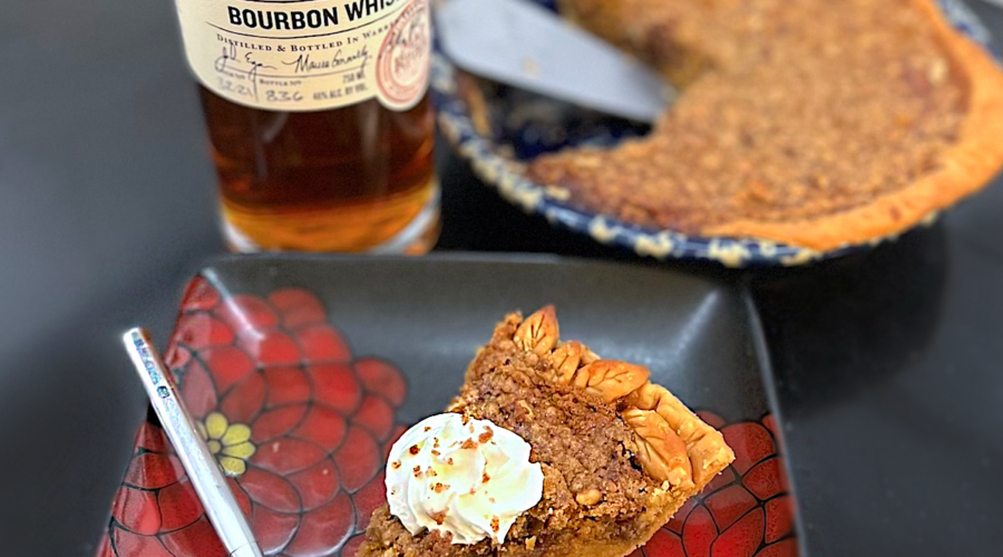 Bourbon Whiskey bottle, pecan pie, and slice of pie on a counter