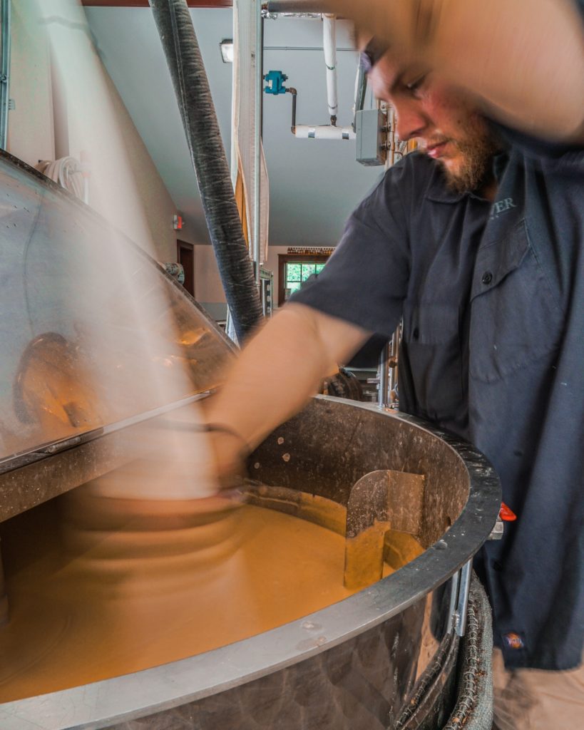 A man working at the Mad River Distiller on Revolution Rye whiskey