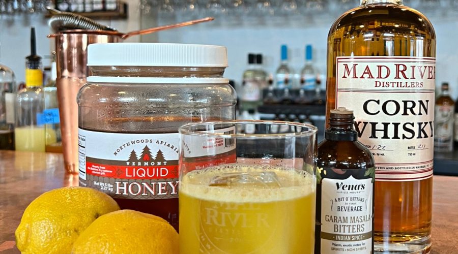 Stolen Gold cocktail with lemons, honey, bitters and a bottle of corn whisky